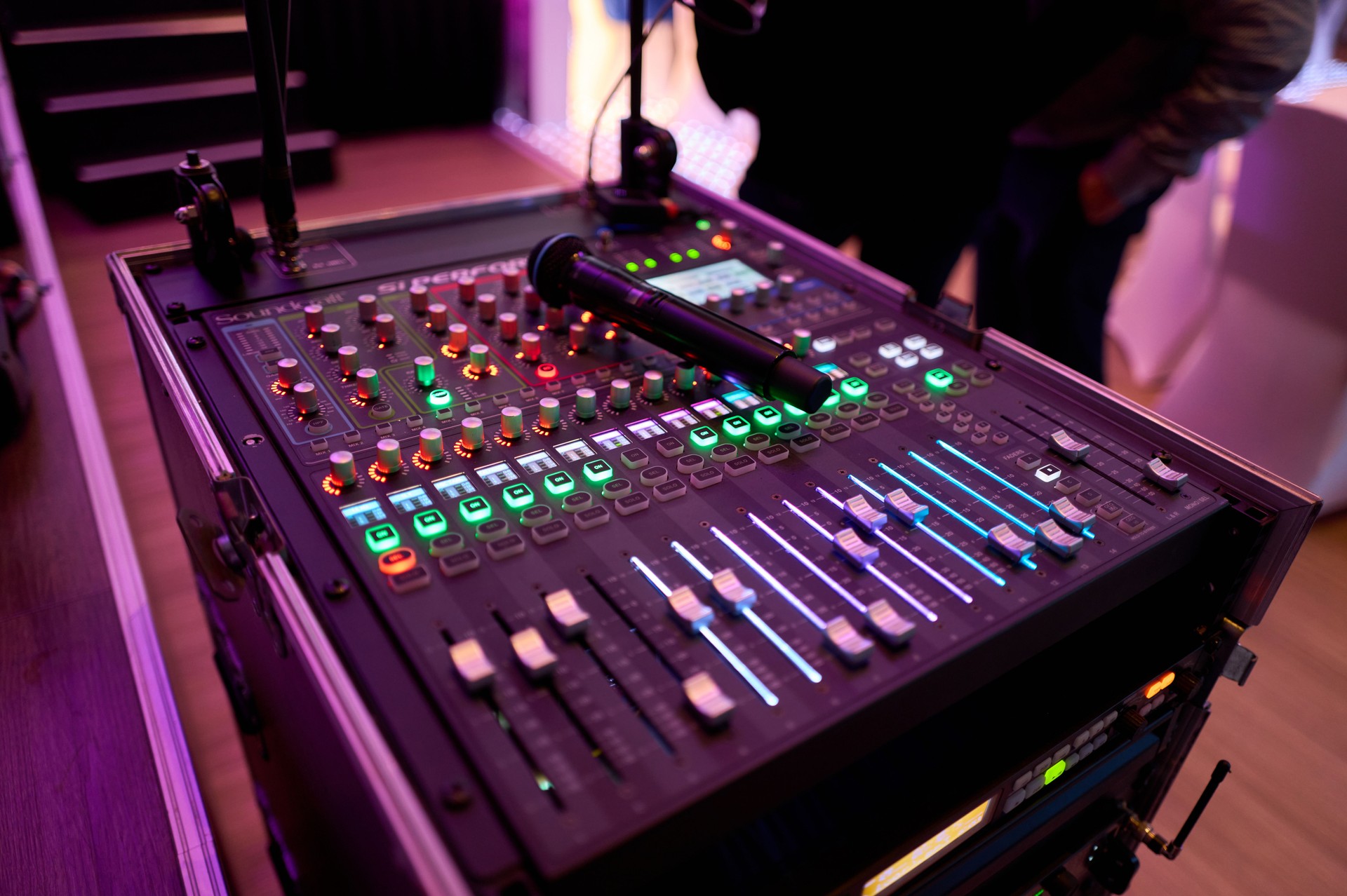 Professional mixing console with microphone and colorful lights displaying sound levels