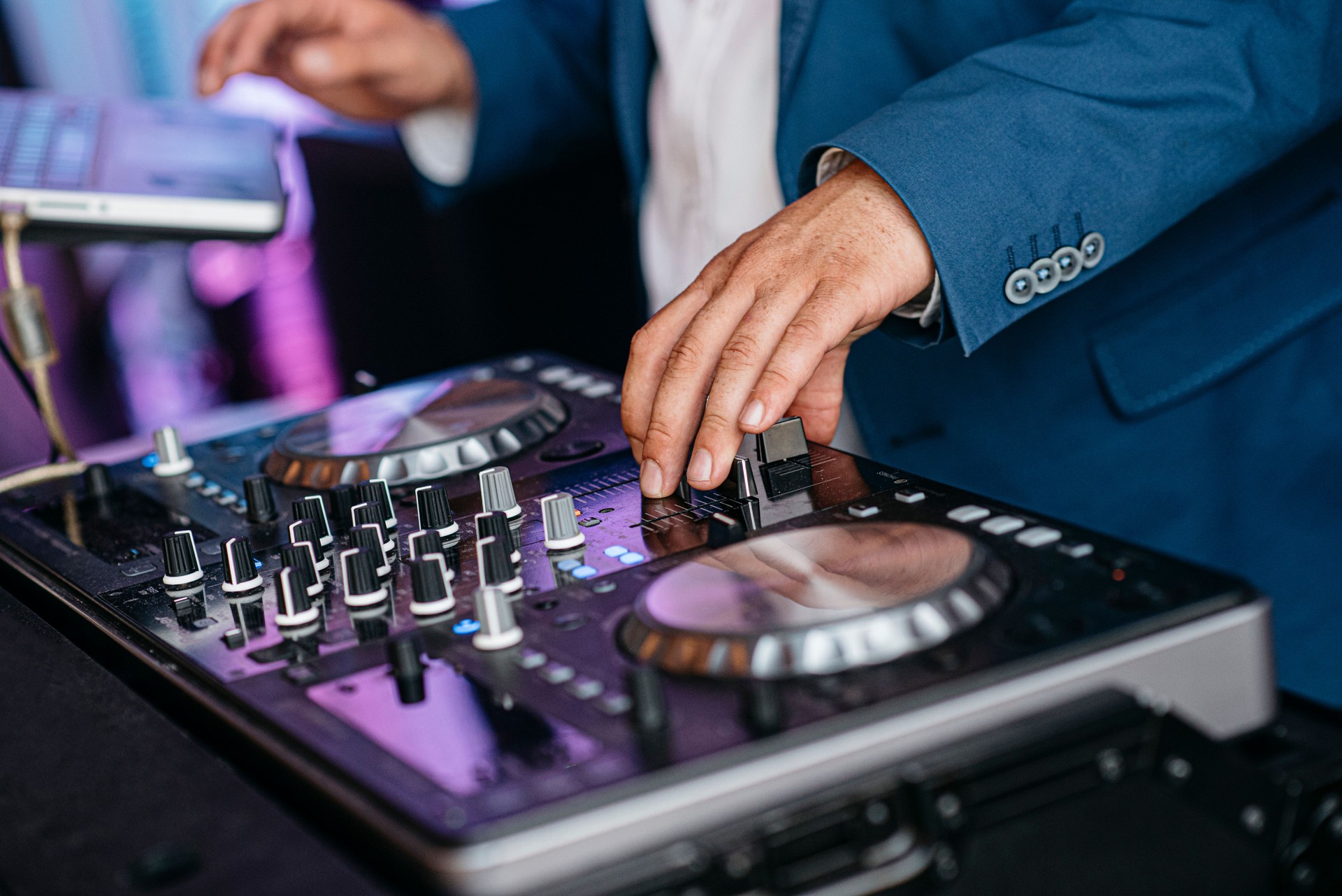 DJ Mixing Music on Professional Controller in Blue Suit
